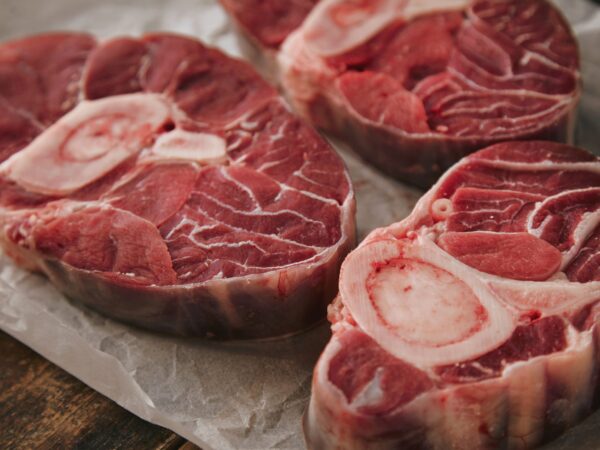 closeup-three-fresh-raw-meat-steaks-with-bone-white-craft-paper-from-top