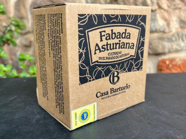 Autentica Fabada Asturiana La foto muestra la caja en la que va envasada nuestra fabada asturiana, sobre un fondo de piedra.