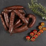 Ristra de chorizos con tomates en fondo negro