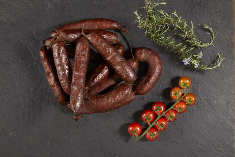 Ristra de chorizos con tomates en fondo negro